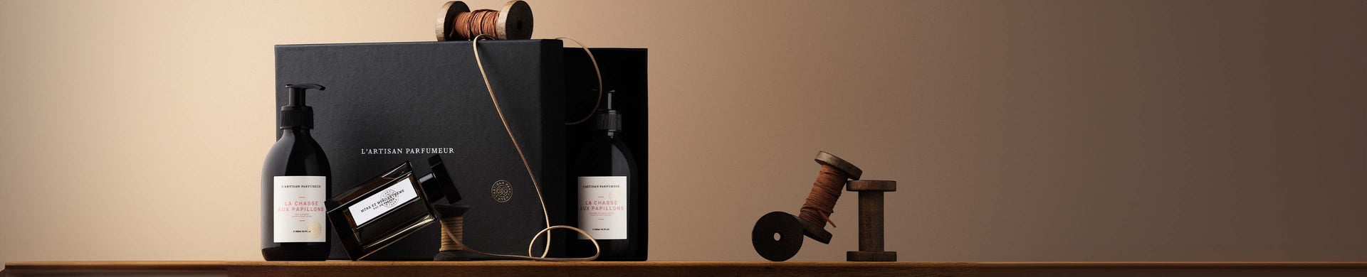 a collection of fragrance and body wash products around a luxurious black box decorated with brown spools of twine.jpg