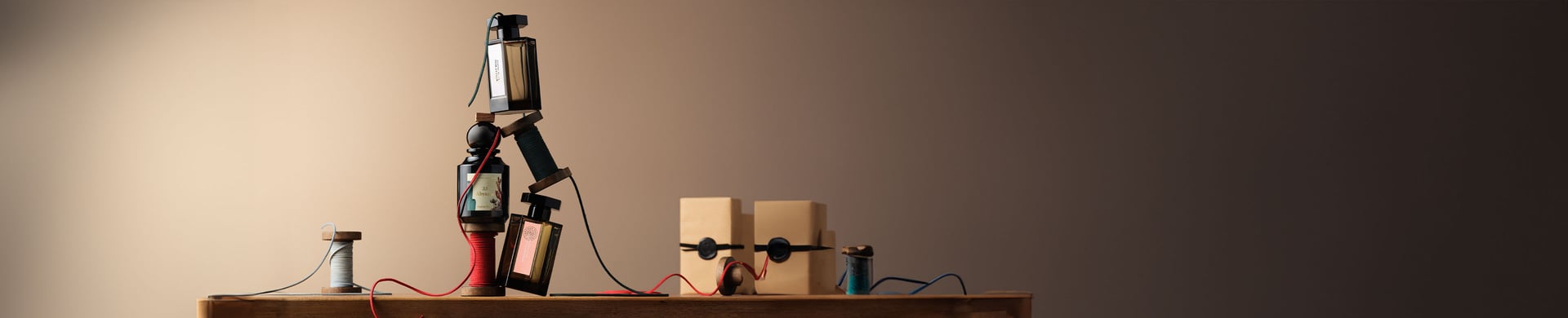 Perfume bottles with gift boxes and ribbon on beige background